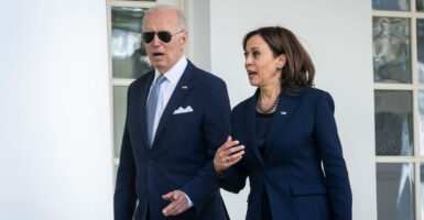 Joe Biden, open-mouthed and wearing aviator glasses, walks with an animated Kamala Harris outside the Oval Office.