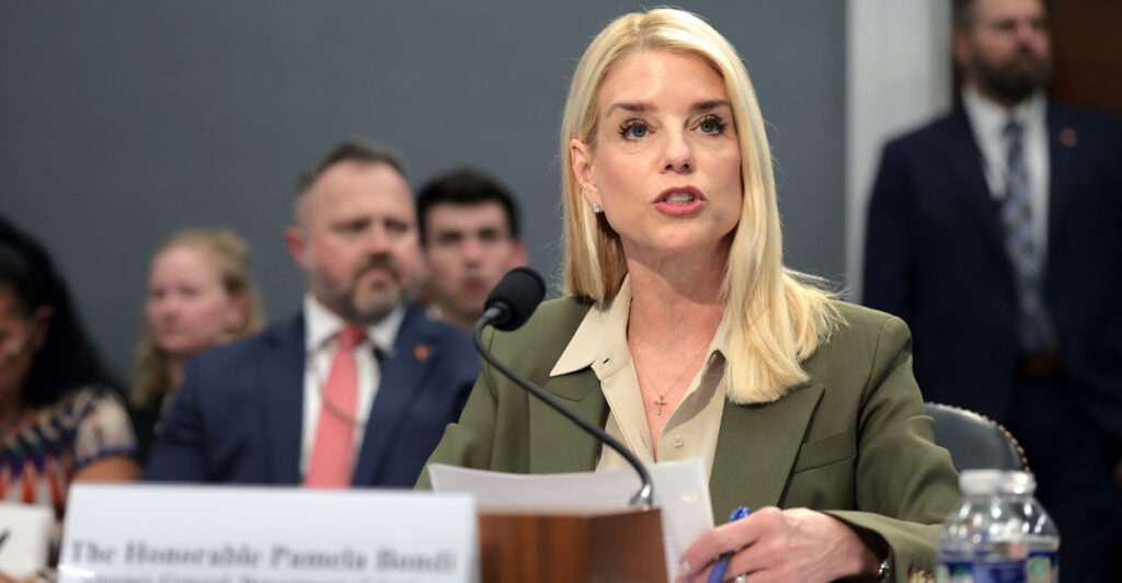 Attorney Pam Bondi, in an army green jacket, testifies at a House hearing.