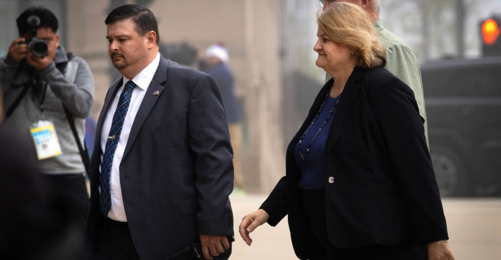 Milwaukee County Circuit Judge Hannah Dugan walks into the Milwaukee Federal Courthouse with suited man at her side.