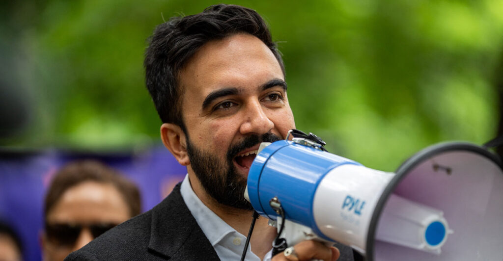 Close-up of Zohran Mamdani speaking into a megaphone.
