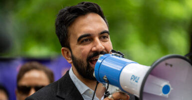 Close-up of Zohran Mamdani speaking into a megaphone.