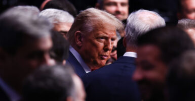 President Donald Trump's head is visible among a crowd of people.