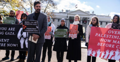 Zohran Mamdani speaking at a 2023 pro-Gaza, anti-Biden protest in front of White House. A group of people are behind him, including actress Cynthia Nixon.