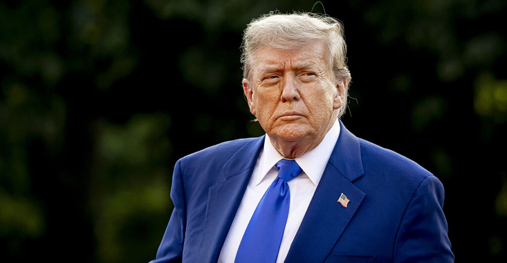 Donald Trump in a blue suit stares resolutely