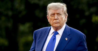 Donald Trump in a blue suit stares resolutely