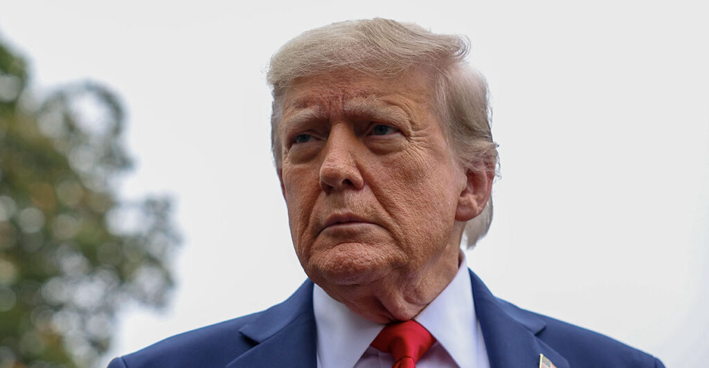 President Donald Trump in a blue suit looks into the distance