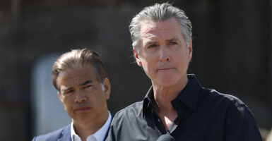 California Gov. Gavin Newsom purses his lips as state AG Rob Bonta looks on.