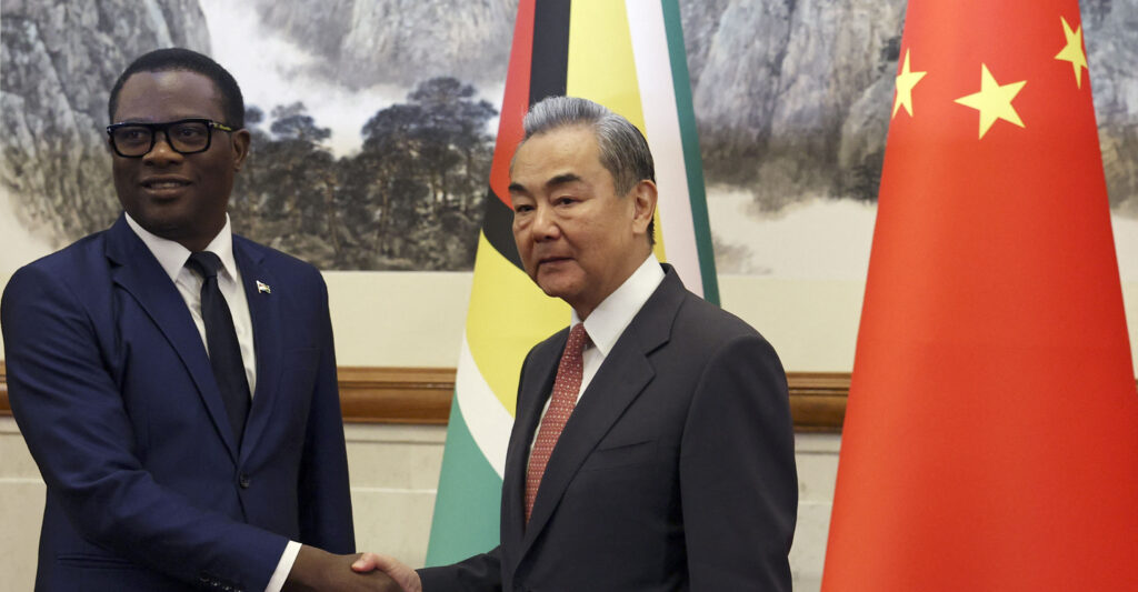 Chinese Foreign Minister Wang Yi (R) and Guyana's Foreign Minister Hugh Todd shake hands before their meeting at the Diaoyutai State Guesthouse in Beijing on May 12, 2025.