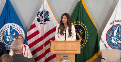 With a backdrop of several flags, DHS Secretary Kristi Noem speaks at Customs and Border Protection’s Advanced Training Center in Harpers Ferry, West Virginia, on Monday.