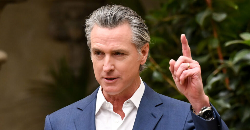 California Gov. Gavin Newsom in a jacket and white shirt, but without a tie.