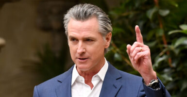 California Gov. Gavin Newsom in a jacket and white shirt, but without a tie.