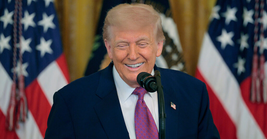 President Donald Trump, with two U.S. flags as backdrop