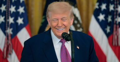 President Donald Trump, with two U.S. flags as backdrop