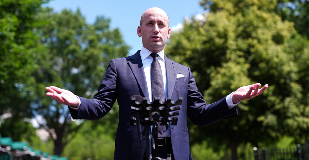 White House Deputy Chief of Staff Stephen Miller addresses media outdoors, arms outstretched.