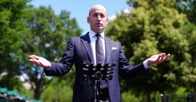 White House Deputy Chief of Staff Stephen Miller addresses media outdoors, arms outstretched.