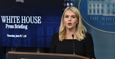 Karoline Leavitt, dressed in a dark outfit, speaks at a White House press briefing.