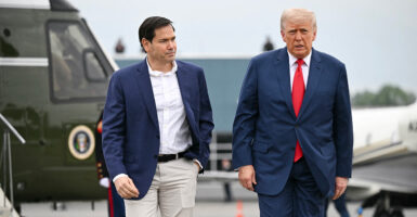 President Donald Trump and Secretary of State Marco Rubio walk in front of a helicopter.