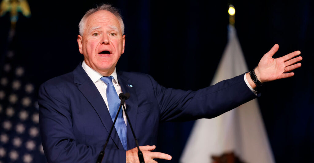 Minnesota Gov. Tim Walz, addresses a gathering, perhaps fittingly with his left arm extended.