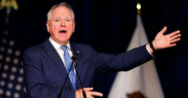 Minnesota Gov. Tim Walz, addresses a gathering, perhaps fittingly with his left arm extended.