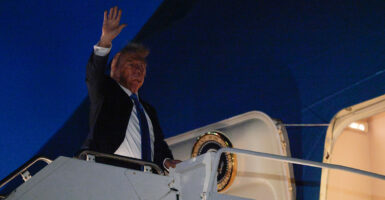 President Trump waves from the top of the stairs entering Air Force One before departing Canada late Monday night.