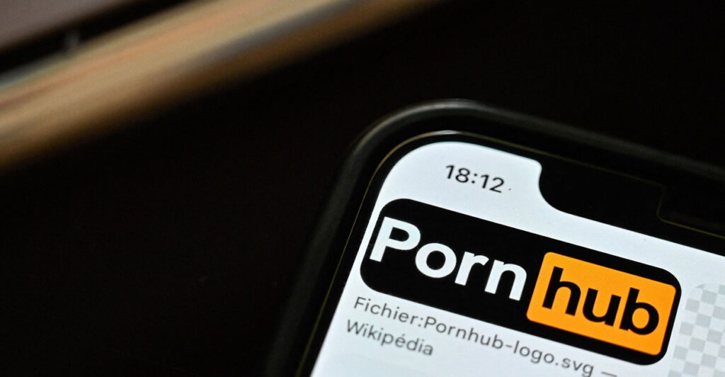 A cell phone is on and the screen has the PornHub website on it.
