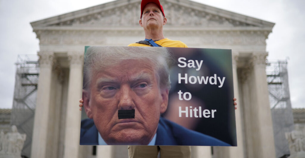 A man with a sign equating President Donald Trump to Adolf Hitler protests in a possible manifestation of Trump Derangement Syndrome at the Supreme Court