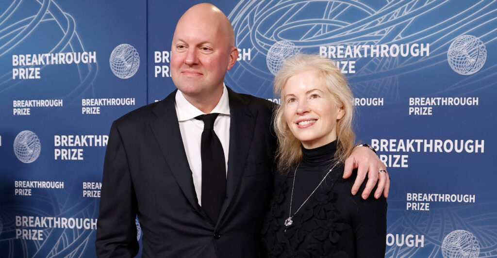 Marc Andreessen puts his left arm around the shoulder of Laura Arrillaga-Andreessen as they stand on a red carpet.