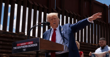 Donald Trump extends his left arm while speaking at an event at the border wall.
