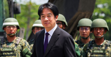 Taiwanese President Lai-Ching Te in black suit, backed by a number of Taiwanese soldiers.