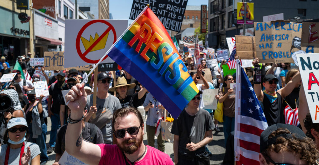 Protesters with signs and flags fill a street in Los Angeles during a "No Kings" demonstration.