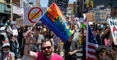 Protesters with signs and flags fill a street in Los Angeles during a "No Kings" demonstration.