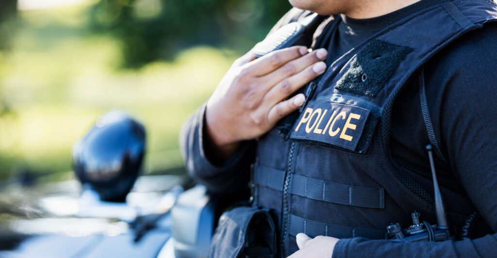 A police officer holds his right hand over his heart