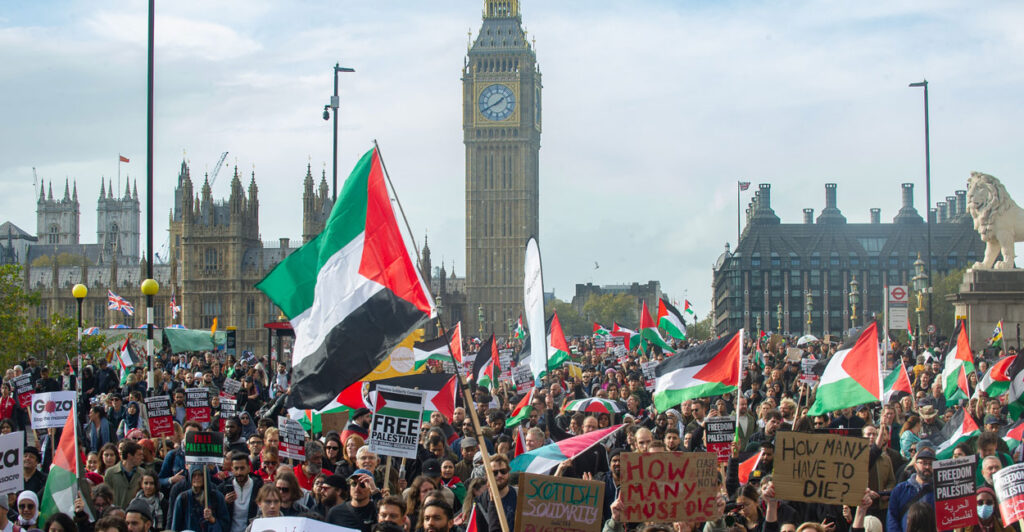 Huge crowd of pro-Palestinian protesters swarm a London street. Big Ben is seen in background.