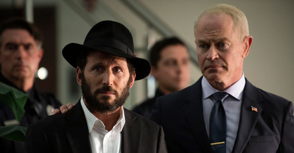 Actors Mark Feurstein as Rabbi Mo and Neal McDonough as Mayor Donovan Kirk stand together in a scene from "Guns and Moses."