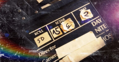 A movie clapperboard against a spacy black and rainbow background.