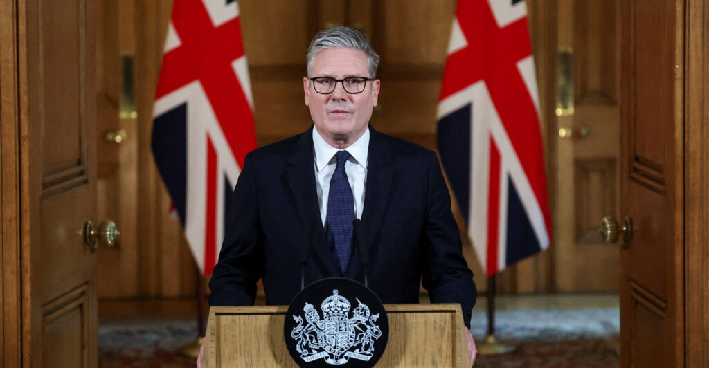 British Prime Minister Keir Starmer stands behind a podium delivering a speech.