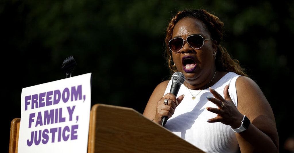April Verrett in white holds a microphone