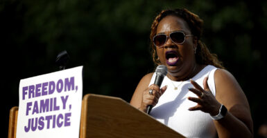 April Verrett in white holds a microphone