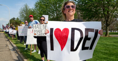 protesters along the street. The one in front is holding a sign that says I love DEI
