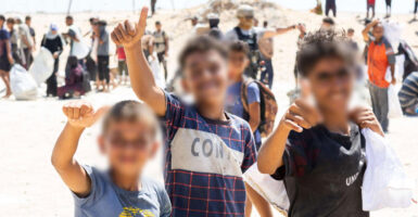 Children pose for a photo at a Gaza Humanitarian Foundation aid site in Gaza.