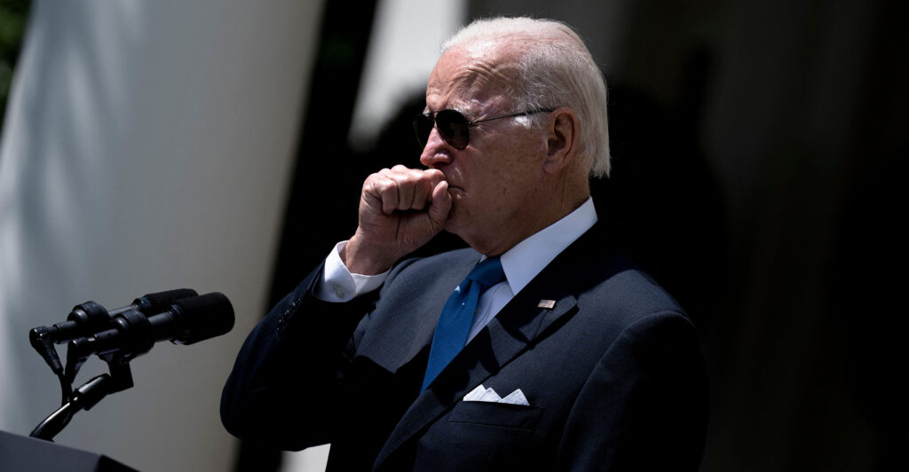 Side view of Joe Biden coughing during an outdoor White House event.
