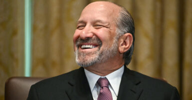 Lutnick smiles with closed eyes at the camera.