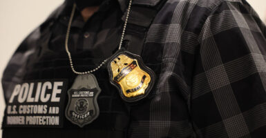 Close up of ICE agent vest and badge.