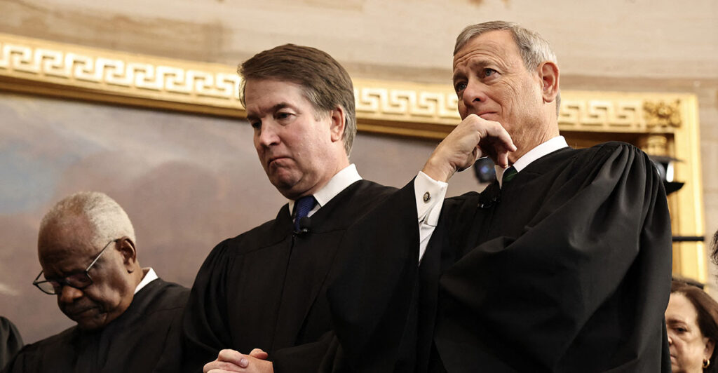 Clarence Thomas, Brett Kavanaugh, and John Roberts stand together in contemplation.