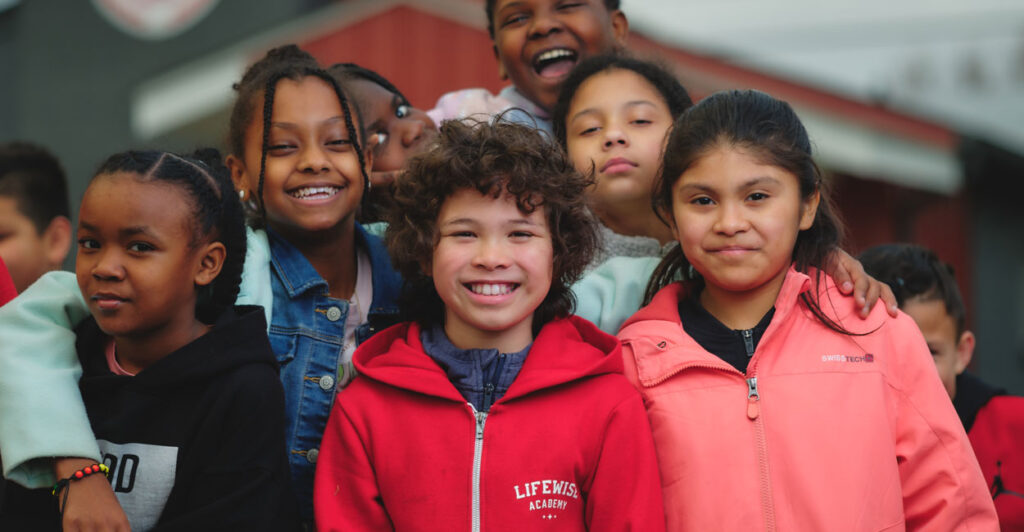 Smiling young students, including those in LifeWise Academy gear, pose for a picture.