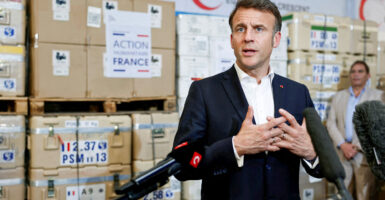 French President Emmanuel Macron talks to reporters during a visit at Egyptian Red Crescent warehouses storing aid for Gaza in the Egyptian border town of El-Arish, Egypt, on April 8.