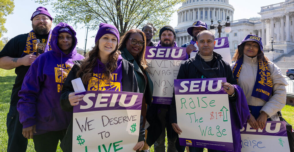 SEIU President April Verrett and others pose in front of the Capitol