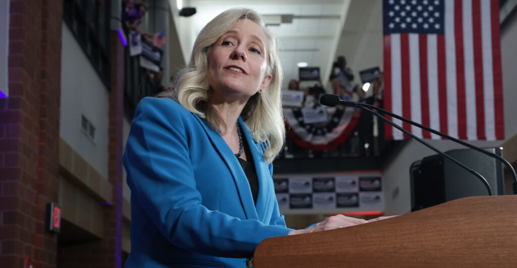 Abigail Spanberger in a light blue suit jacket speaking at a podium