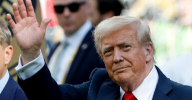 President Donald Trump waves to onlookers.
