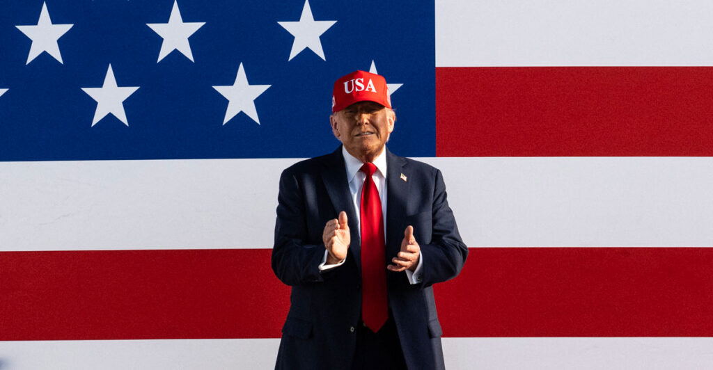 President Donald Trump with a giant American flag as backdrop